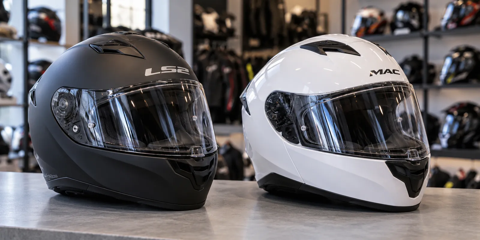 Casco LS2 negro y casco MAC blanco sobre un mostrador de un local de cascos